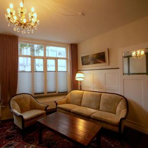 a living room with a couch and a table and a chandelier at Barrierefreie Unterkunft - Fachwerk mit Flair in Osterode