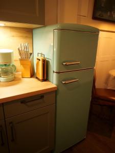 a green refrigerator in a kitchen next to a counter at Barrierefreie Unterkunft - Fachwerk mit Flair in Osterode