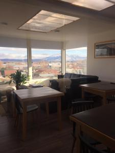 salon z kanapami i stołami oraz dużym oknem w obiekcie Xalpen B&B w mieście Puerto Natales
