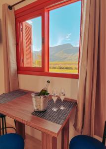 - une table avec deux verres à vin et une fenêtre dans l'établissement Pousada Paredão dos Canyons, à Praia Grande