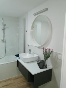 a white bathroom with a sink and a mirror at Appartementhaus 10 Seen in Waren