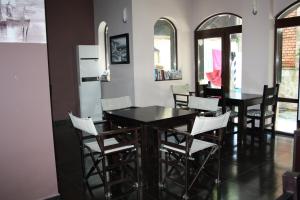 a dining room with a black table and white chairs at Saint Sofia Guest House Къща за Гости in Nesebar