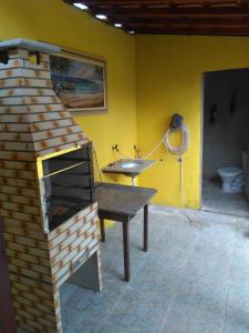 uma casa de banho com um forno de tijolo e um lavatório. em Casa de temporada Lindas Cachoeiras 10 em Paraty
