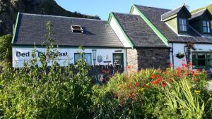 a bed and breakfast with a garden in front of a house at Garragh Mhor in Oban