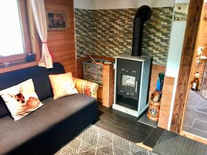 a living room with a couch and a wood stove at Wasserfallhütte Saalbach in Saalbach-Hinterglemm