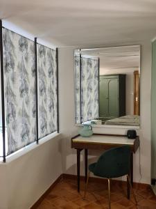um quarto com um espelho, uma secretária e uma cadeira em Pozzuoli Green house em Pozzuoli