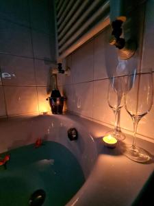een badkuip met twee wijnglazen en een kaars bij Pozzuoli Green house in Pozzuoli