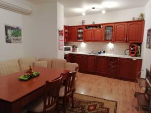 uma cozinha com armários vermelhos e uma mesa de madeira em Къща в центъра на Стрелча, джакузи с минерална вода em Strelcha