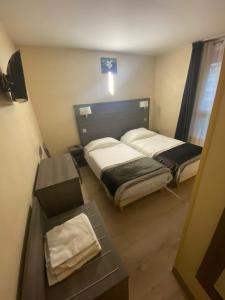 um pequeno quarto com duas camas e uma mesa em Residence Chatillon em Paris