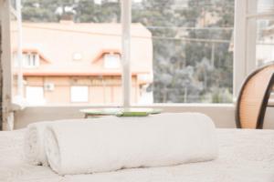 a white towel sitting on top of a table with a window at Pousada FM - Vila Capivari in Campos do Jordão