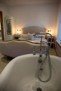 eine Badewanne im Bad mit einem Bett in der Unterkunft Steamy Cottage a cosy couples cottage & steam room in Haworth
