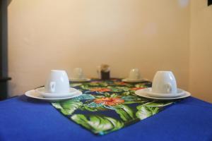 a table with a blue table cloth with dishes on it at Casinha 2 suites in Tiradentes