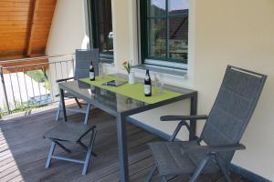 einen Tisch mit zwei Stühlen und zwei Flaschen Wein in der Unterkunft Ferienwohnung Faber mit großem Südbalkon in Essing