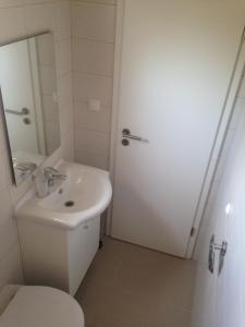 uma casa de banho com um WC branco e um lavatório. em Apartments M&M em Grebaštica