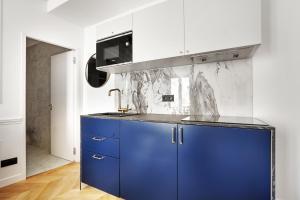 a kitchen with blue cabinets and a sink at Pick A Flat's Apartment on rue Montorgueil in Paris