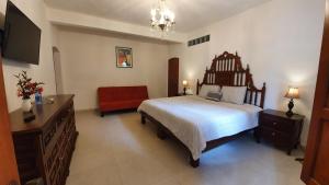 a bedroom with a large bed and a red couch at Casa aroma de café, en el corazón de Coatepec. in Coatepec
