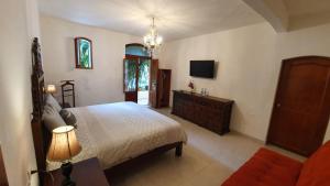 a bedroom with a bed and a dresser and a tv at Casa aroma de café, en el corazón de Coatepec. in Coatepec