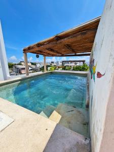 una piscina de agua azul y un techo de madera en Playa Nah, en Playa del Carmen
