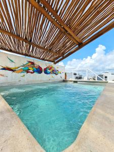una piscina al aire libre con pérgola de madera en Playa Nah, en Playa del Carmen