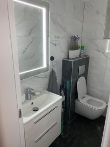 a white bathroom with a sink and a toilet at Royal 2 **** in Slavonski Brod