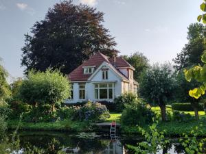 uma casa com um lago em frente em Drenths Landgoed, Welkom thuis em Annerveenschekanaal