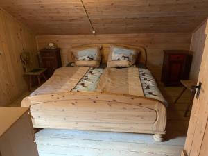 ein großes Bett in einer Holzhütte mit in der Unterkunft Rettenbäckalm in Schliersee