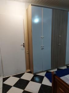 a room with a closet and a door and a checkered floor at Hostel Beto Carrero in Itajaí