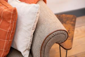 um close-up do braço de um sofá com almofadas em The Hideaway em Great Massingham