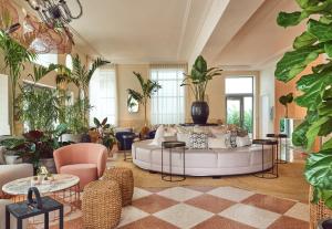 a living room with a white couch and lots of plants at Hotel Greystone - Adults Only in Miami Beach