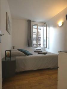 a bedroom with a large bed and a window at Le Capitaine Jack in Trouville-sur-Mer