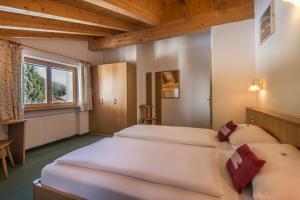 1 dormitorio con 2 camas y ventana en Ciasa Roch, en Corvara in Badia