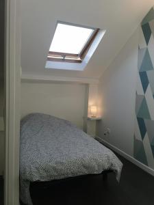 um quarto com uma cama e uma clarabóia em Le Metz, Duplex, 2 Chambres em Le Touquet-Paris-Plage