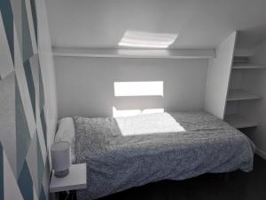 a small bedroom with a bed and a window at Le Metz, Duplex, 2 Chambres in Le Touquet-Paris-Plage
