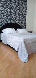 ein Bett mit weißer Bettwäsche und Kissen auf einem Holzboden in der Unterkunft Апартаменти на Чорновола, Порт-сіті in Luzk