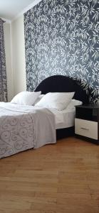 1 dormitorio con 1 cama con pared en blanco y negro en Апартаменти на Чорновола, Порт-сіті, en Lutsk