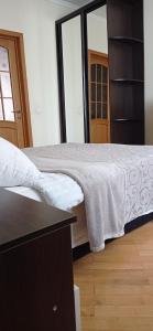 1 dormitorio con 1 cama con manta blanca en Апартаменти на Чорновола, Порт-сіті, en Lutsk