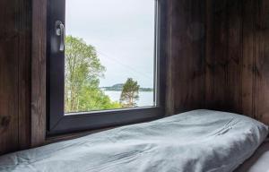 Bett in einem Zimmer mit Fenster in der Unterkunft Atlantic View Ingerstua in Frei