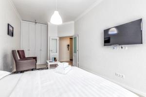 a bedroom with a bed and a chair and a tv at Raisson Ahotel H252 in Taldykolʼ