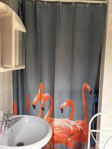 baño con cortina de ducha con flamencos. en Ferienbungalow Karnitz/Rügen, en Karnitz