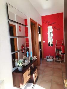 a bathroom with a sink and a red wall at La Dama del Quijote in El Toboso