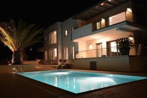 a large swimming pool in front of a house at night at Villa Valsavia-apartment Monsena with pool and SPA in Rovinj