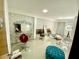ein Wohnzimmer mit einem blauen Sessel und einem Tisch in der Unterkunft Hotel Skalla - MELHOR CUSTO BENEFICIO in Teixeira de Freitas