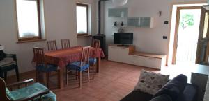 kuchnia i jadalnia ze stołem i krzesłami w obiekcie Casa Sonia w mieście Auronzo di Cadore