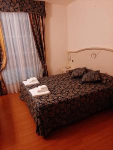 a hotel room with a bed and a dresser at Hotel Vedute in Fucecchio