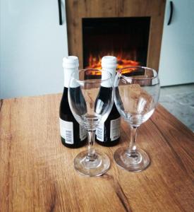 zwei Flaschen Wein und zwei Gläser auf dem Tisch. in der Unterkunft Apartman Zlatibor Philautia in Zlatibor