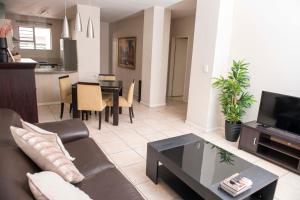 ein Wohnzimmer mit einem Sofa und einem Tisch in der Unterkunft Grayston Exec Apartments in Johannesburg