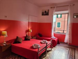 een rode kamer met 2 bedden en een raam bij Relax ON 247 in Rome