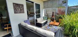 a patio with a couch and a chair and a table at Goat Island Bungalow in Ulverstone