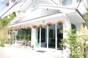 a white building with flowers on the facade at Jasmine Chiangmai Boutique Hotel in Chiang Mai