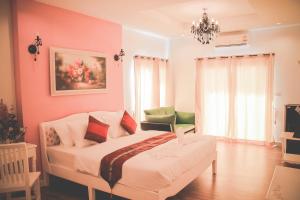a pink bedroom with a bed and a couch at Jasmine Chiangmai Boutique Hotel in Chiang Mai